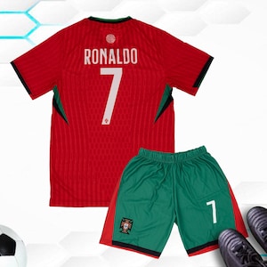 May include: Red and green soccer jersey with the name "Ronaldo" and the number "7" on the back. The jersey is part of a soccer uniform set that also includes green shorts with a white "7" on the side.