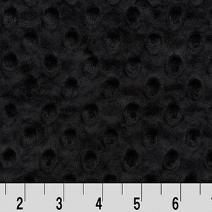 May include: Black minky dot fabric with a subtle texture. The fabric is shown with a ruler for scale.