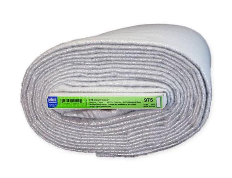 May include: A roll of Pellon 975 Insul-Fleece crafting fabric. The fabric is white and is rolled up tightly. The label on the fabric reads "975 Insul-Fleece" and lists the fabric's composition as 87.5% Polyester, 12.5%  Recycled  Fiber.