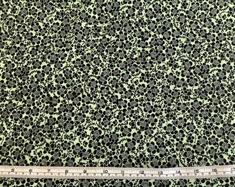 May include: Black and green fabric with a small floral pattern. The fabric is measured with a ruler in inches.
