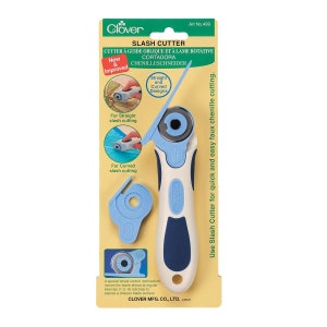 May include: A white and blue slash cutter with a rotating blade for quick and easy faux chenille cutting. The cutter has a special wheel control mechanism that moves the blade ahead at regular intervals to expose a sharper blade surface.  The packaging shows a green background with the text "Slash Cutter" and "Clover" in green.