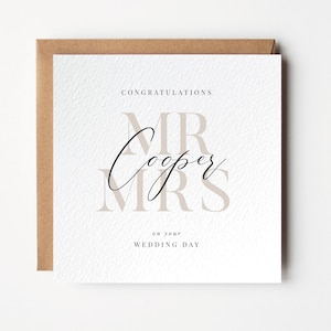 Square white wedding card with Mr and Mrs in large beige letters. Across the centre is the personalised surname in black. The card reads, congratulations on your wedding day.