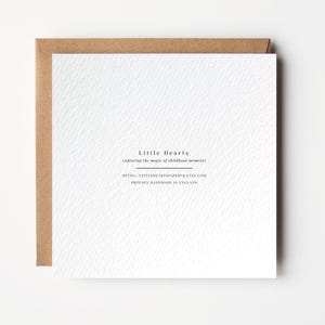 Puede incluir: Tarjeta blanca con borde marr&oacute;n. La tarjeta tiene texto negro que dice "Little Hearts capturing the magic of childhood moments" y "https://littleheartspaper.etsy.com Proudly handmade in England."