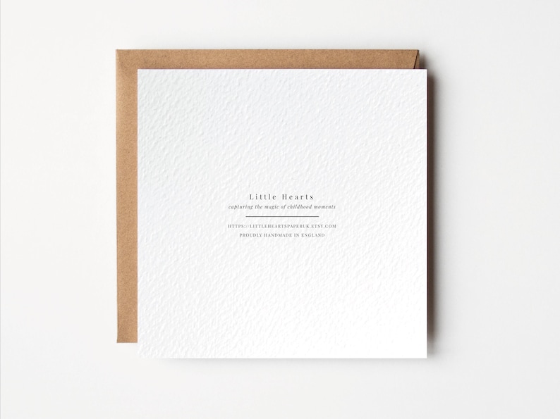 Puede incluir: Tarjeta blanca con borde marr&oacute;n. La tarjeta tiene texto negro que dice "Little Hearts capturing the magic of childhood moments" y "https://littleheartspaper.etsy.com Proudly handmade in England."