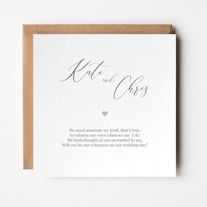 Può includere: Un biglietto bianco con calligrafia nera che recita "Kate e Chris". Il biglietto ha un piccolo cuore grigio e un testo che dice "Abbiamo bisogno di qualcuno di cui ci fidiamo, è vero, per essere testimoni dei nostri voti quando diremo 'sì, lo voglio'. Entrambi abbiamo pensato a te e volevamo dirtelo. Vuoi essere i nostri testimoni il giorno del nostro matrimonio?"