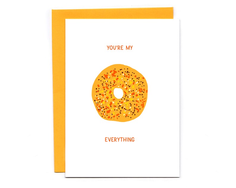 May include: A white card with the text "You're my Everything" and a cartoon image of a yellow bagel with orange and black sprinkles.