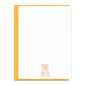 May include: Blank greeting card with a yellow border and a small, orange rectangle in the bottom right corner with the text "CATS LOCK" in white, "BLANK INSIDE" in black, "PRINTED IN NJ" in black, and "CATSLOCK.COM" in black.