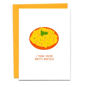May include: A white card with a yellow and orange illustration of a bowl of spaetzle. The text on the card reads "I think you're pretty spaetzle."