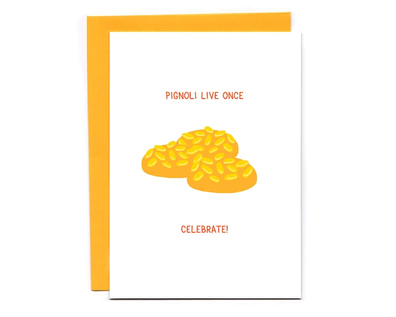 May include: A white card with the text "PIGNOLI LIVE ONCE" in orange.  Below the text is a cartoon image of three yellow pignoli cookies.  The text "CELEBRATE!" is below the image.