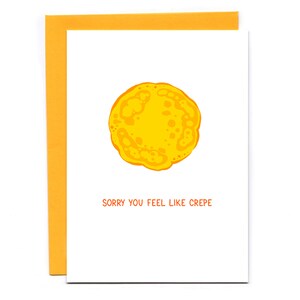 May include: A white card with a yellow crepe illustration and the text "Sorry you feel like crepe".