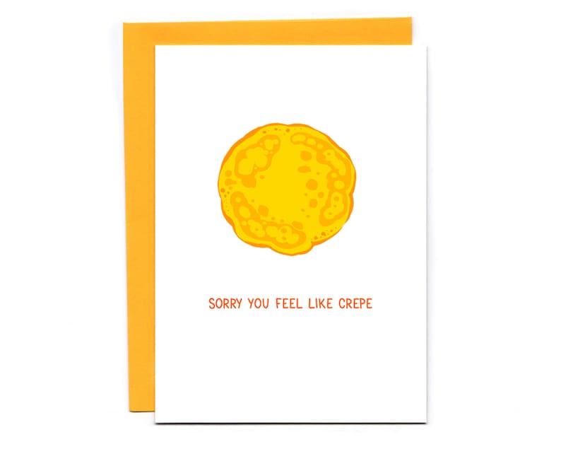 May include: A white card with a yellow crepe illustration and the text "Sorry you feel like crepe".