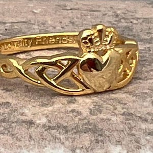 14 kt goudgecoate sterlingzilveren claddagh-ring met twee drie-eenheden aan weerszijden van het hart. Controleer de beschikbaarheid voor de maten.