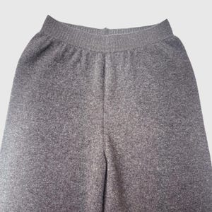 May include: Grey sweatpants with a ribbed waistband.
