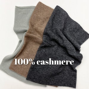 May include: Three scarves in different shades of grey, brown, and beige, made of 100% cashmere.