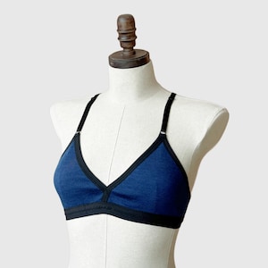 May include: A blue and black triangle-shaped bra with adjustable straps.