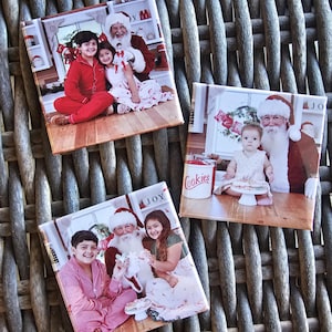 Op de afbeelding: Drie foto's van kinderen met de kerstman. De eerste foto toont twee kinderen die op de grond zitten met de kerstman die achter hen staat. De tweede foto toont een jong kind dat op een stoel zit met de kerstman die achter hem staat. De derde foto toont twee kinderen die op de grond zitten met de kerstman die op de grond voor hen zit. Alle drie foto's hebben een kerstthema.