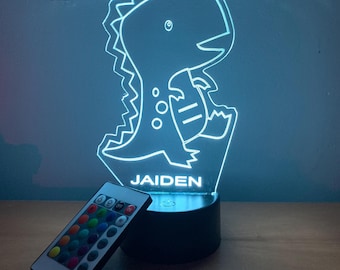 May include: A blue dinosaur night light with a remote control. The light has a personalized name, "JAIDEN", on the base.