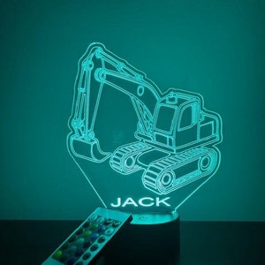 May include: A teal blue 3D printed night light shaped like an excavator with the name "JACK" printed below. The night light is on a black base and comes with a remote control.