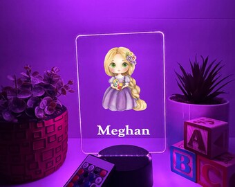 Könnte beinhalten: Personalisiertes LED-Nachtlicht mit einer Cartoon-Prinzessin mit blonden Haaren und einem lila Kleid. Der Name "Meghan" wird darunter angezeigt. Inklusive Fernbedienung zur Farbeinstellung.