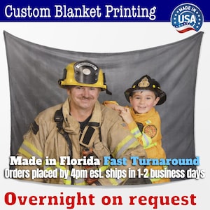 May include: A custom printed fleece blanket featuring a photo of two firefighters, one wearing a yellow helmet with the word "ENGINEER" on it, and the other wearing a red helmet. The text "Made in Florida Fast Turnaround Orders placed by 4pm est. ships in 1-2 business days Overnight on request" is printed at the bottom of the blanket.