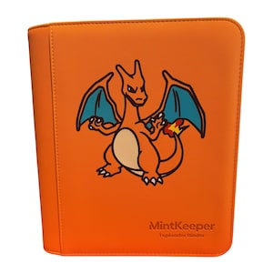 Può includere: Un raccoglitore per carte collezionabili arancione con la grafica di una creatura simile a un drago con ali blu e una fiamma sulla coda. Il testo MintKeeper Toploader Binder è impresso nell'angolo in basso a destra della copertina.