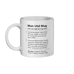May include: White ceramic mug with a black design that defines "Man Utd Mug" as a drinking vessel often filled with tea, coffee, or tears of a United fan reminiscing about 1999. It also describes a devoted Manchester United supporter known for living off past glory, pretending they're still a top club, and watching other teams win everything. The text also includes "See also: Living In The Past, Treble Trauma, Transfer Flops."