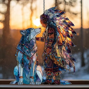 May include: Stained glass artwork featuring a Native American figure and a wolf. The figure wears a feathered headdress and detailed clothing. The wolf is blue and white. The artwork is set against a blurred background of a sunset.
