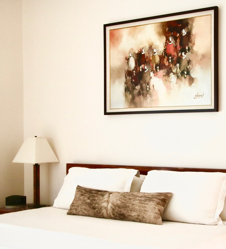 May include: A white bed with a brown headboard and white bedding. There is a brown throw pillow on the bed. A framed painting of a group of people in red and brown clothing hangs on the wall above the bed. The painting has a white background with a light brown and red abstract design.