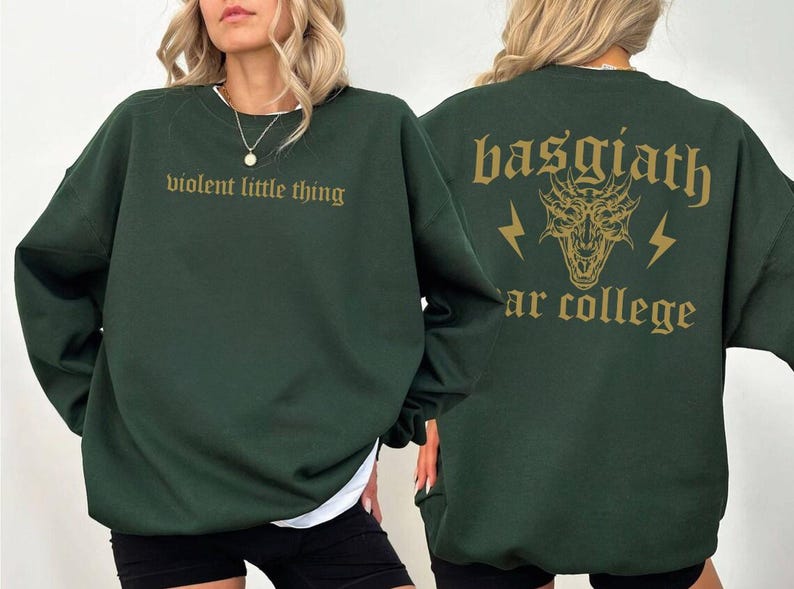 Pode incluir: Uma camisa de moletom verde escura com o texto "violent little thing" na frente e "basgiath" com um gr&aacute;fico de drag&atilde;o e o texto "ar college" nas costas.