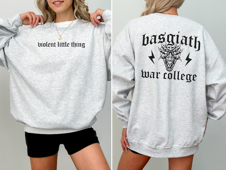 Pode incluir: Camisola de moletom cinza com o texto "violent little thing" na frente e "basgiath war college" com um gr&aacute;fico de drag&atilde;o nas costas.