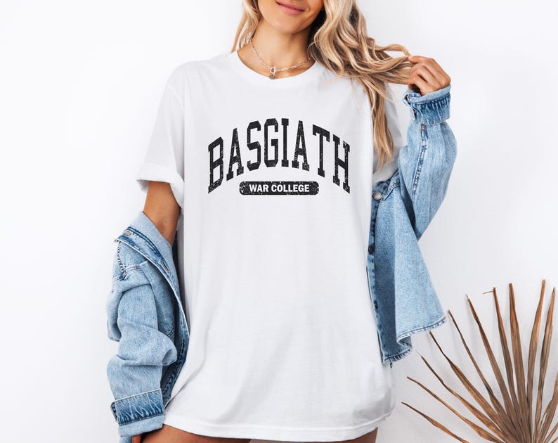 Op de afbeelding: Wit T-shirt met een zwarte afbeelding met de tekst "Basgiath War College" in een vintage universitaire lettertype.