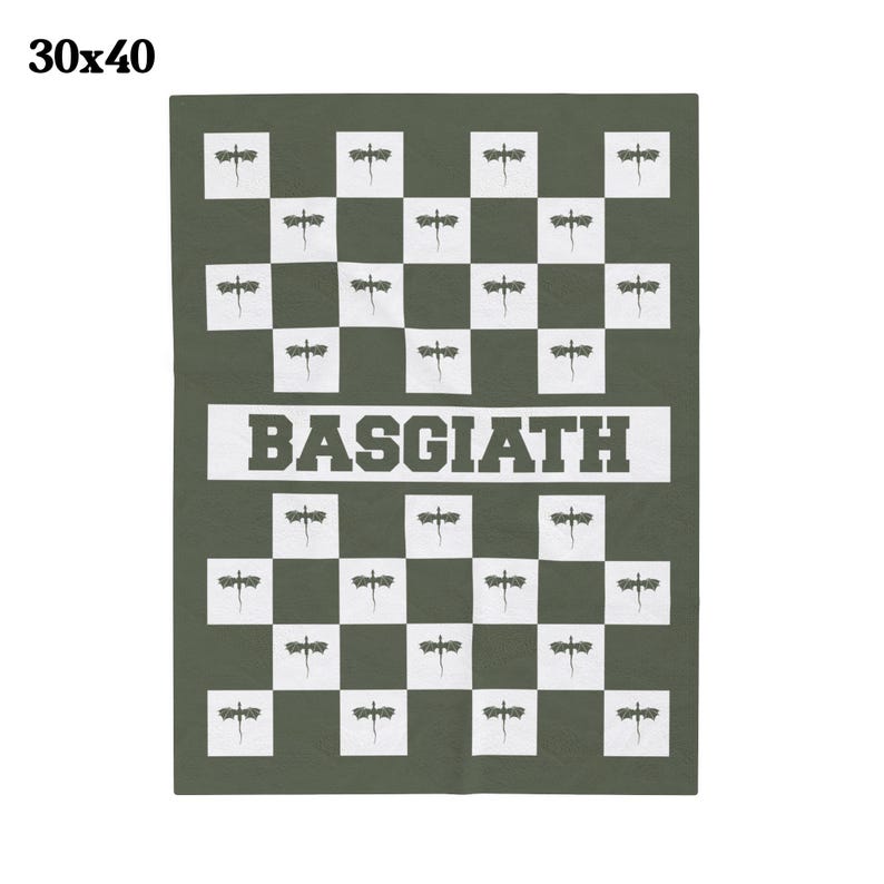 K&ouml;nnte beinhalten: Eine gr&uuml;n-wei&szlig;e karierte Wolldecke mit einem sich wiederholenden Muster aus stilisierten Libellen. Die Decke hat das Wort "BASQUIAT" in wei&szlig;en Buchstaben auf einem schwarzen Band in der Mitte aufgedruckt.