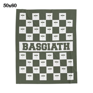 K&ouml;nnte beinhalten: Eine gr&uuml;ne Wolldecke mit einem karierten Muster, das Libellen-Silhouetten zeigt. Die Decke tr&auml;gt den Schriftzug "BASGIATH" in wei&szlig;en Buchstaben.