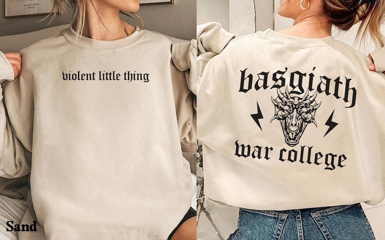 Pode incluir: Duas sweatshirts bege com designs gr&aacute;ficos diferentes. Uma sweatshirt diz "violent little thing" e a outra diz "basgiath war college" com um gr&aacute;fico de drag&atilde;o.