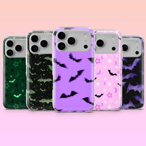 Op de afbeelding: Vijf telefoonhoesjes met Halloween-thema's. De hoesjes hebben patronen van vleermuizen, sterren en manen, in kleuren als groen, zwart, paars en roze. De hoesjes zijn transparant met een gekleurd ontwerp op de achterkant.