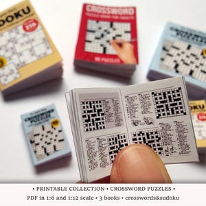 May include: A collection of miniature puzzle books, including Sudoku and crossword puzzles. One book is open, revealing crossword grids. The image includes the text "PRINTABLE COLLECTION CROSSWORD PUZZLES".