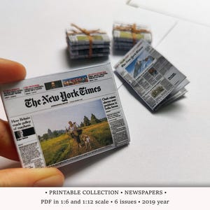 Puede incluir: Réplica en miniatura del periódico The New York Times sostenida por una mano, con otros periódicos en miniatura en el fondo. El titular dice "How Britain made policy of mayhem". La imagen también incluye texto sobre la colección imprimible de periódicos.