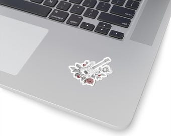 Op de afbeelding: Een witte sticker met een gedetailleerde illustratie van een elektrische gitaar, omringd door rozen en bladeren. De gitaar staat centraal, met de bloemelementen eromheen gerangschikt. De sticker bevindt zich op een laptop.