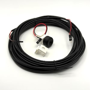 May include: A long black electrical cable coiled in a circle, featuring a black cylindrical sensor component attached to a white plastic mount with red and black wires ending in a two-pin connector, plus an additional separate white plastic bracket.