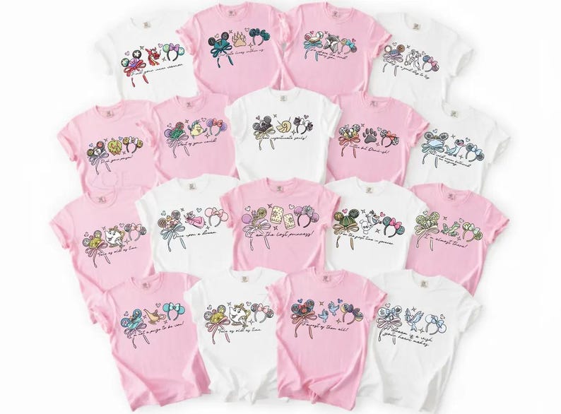 May include: A selection of pink and white t-shirts, each adorned with cartoon character illustrations. The designs include character ears, bows, and text, creating a whimsical aesthetic. The shirts are arranged in a circular pattern, showcasing the variety.