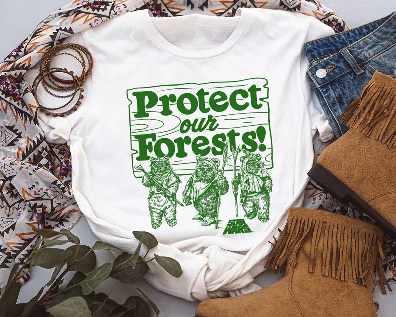 May include: White t-shirt with a green graphic of a wooden sign that says "Protect our Forests!" with three Ewoks from Star Wars standing in front of it.