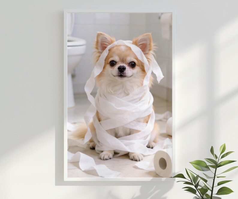 May include: A framed print featuring a light brown Chihuahua wrapped in white toilet paper. The dog is sitting in a bathroom setting with a toilet in the background. The dog is looking directly at the camera.