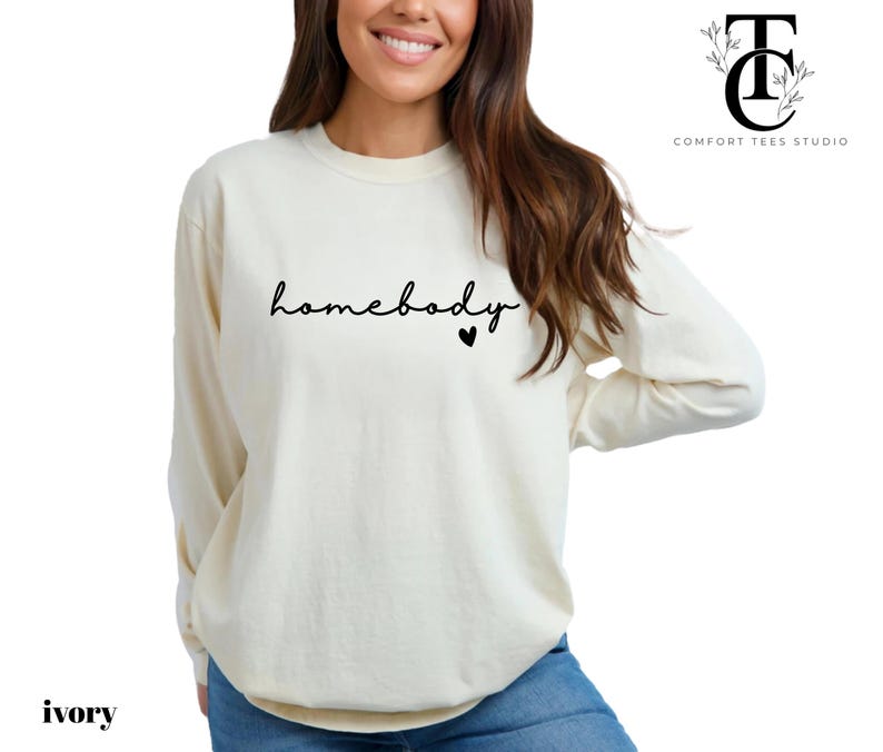May include: A long-sleeved, ivory-coloured sweatshirt with the text "homebody" in black script and a small black heart.