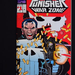 Op de afbeelding: Stripboekcover voor "The Punisher War Zone" #1. De cover toont een schreeuwend personage met een schedel-embleem op zijn borst, die een wapen afvuurt. De achtergrond is rood met een witte schedel en gele hulzen.