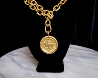 Collar con colgante y cadena con el logotipo de Chanel vintage.