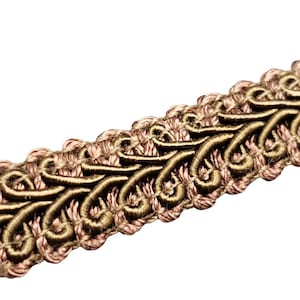 May include: Close-up of decorative trim with a repeating pattern. The trim features a light brown base with dark brown, swirling embroidered details. The trim is likely used for embellishing clothing or home decor items.