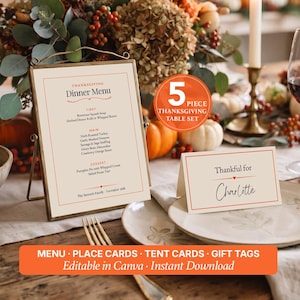 May include: A 5-piece Thanksgiving table set featuring a dinner menu in a gold frame and a place card with the text Thankful for Charlotte. The cream-colored paper items have red borders and black text, designed for a holiday table setting.