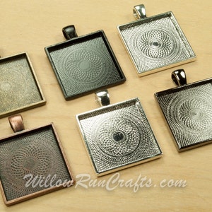 May include: Six square pendant trays in different metal finishes: antique brass, black, silver, and copper. Each tray has a decorative, concentric circle pattern.
