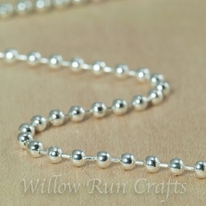 May include: A silver ball chain with a smooth, shiny finish. The chain is made of metal beads and is perfect for jewelry making or crafting.