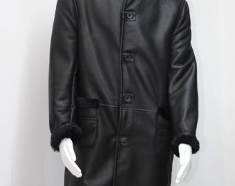 May include: A black hooded shearling coat with a button closure. The coat has a long length and is made of a soft, luxurious material.
